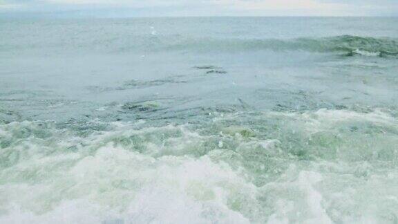 波浪和水花的特写海浪拍打着海岸沙滩上的石头强大的海浪拍打着贝加尔湖的岩石海岸贝加尔湖清澈透明的湖水美丽的自然景观