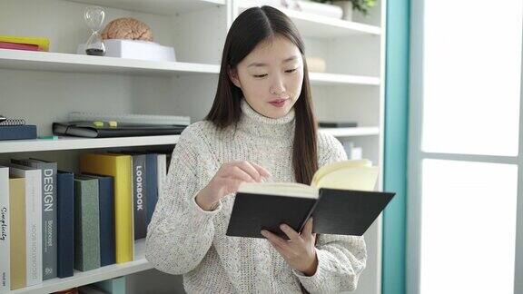 年轻的中国女学生在图书馆大学读书