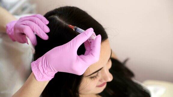 针消脂美容师在女人的头部注射增强头发和它们的生长