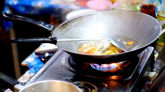 在宗田夜市用煎锅准备亚洲食物的女小贩泰国芭堤雅