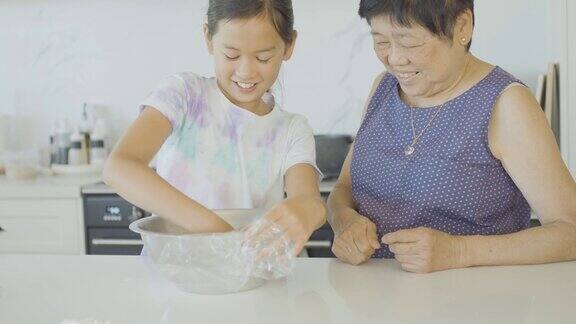 亚洲祖母教她的孙女如何做中国蒸包几代人在家里一起做饭