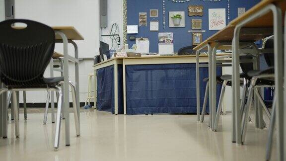 教室前面的教师办公桌旁边排列着桌椅