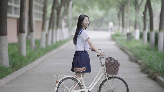 年轻的亚洲妇女骑自行车上学