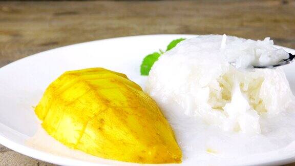 芒果和糯米泰国甜点是由成熟的芒果和糯米煮熟吃前撒上椰奶尝一尝甜