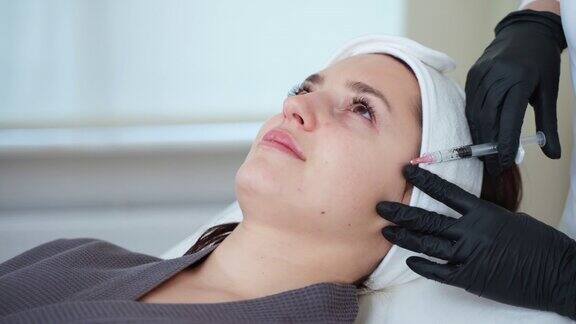 美容师正在为女性客户使用可注射的填充剂来恢复面部肌肤活力