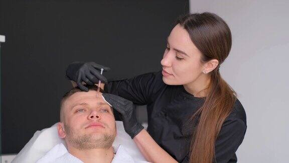 一位女美容师给一位男士的前额注射恢复活力的针剂