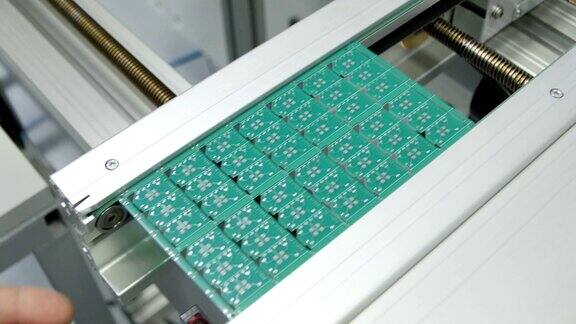 工人在生产线上放置带芯片的绿色板材