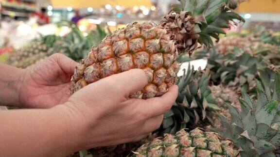 在超市挑选菠萝的女人