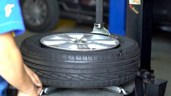 轮胎维修人员用专用工具给汽车车轮装上轮胎