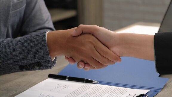 特写亚洲商人签署合同后握手成为合作伙伴慢动作拍摄