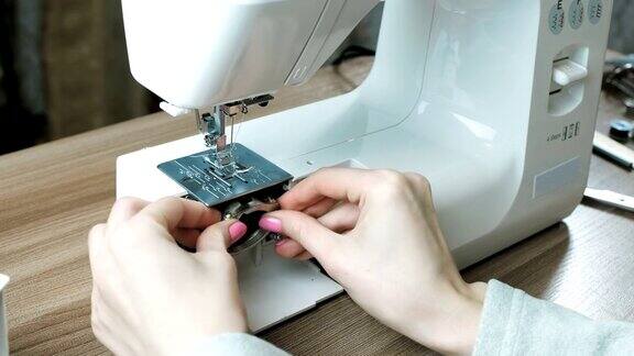 特写妇女的手收集缝纫机插入部件到位侧视图
