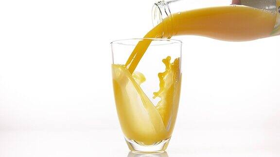 在白色背景下将橙汁倒入玻璃中慢动作4K