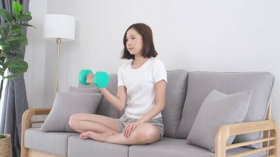 年轻的亚洲妇女锻炼锻炼在家里的客厅