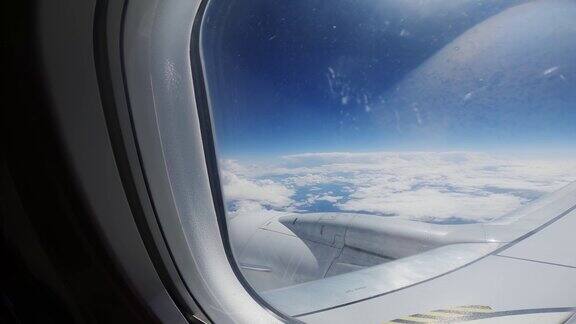 从飞机窗户看飞机机翼、发动机和云层