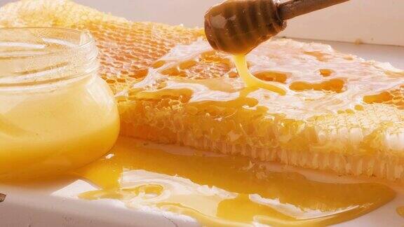 蜂蜜从蜜匙滴到蜂房架上天然液体蜂蜜从滴管上滴到蜂蜡上