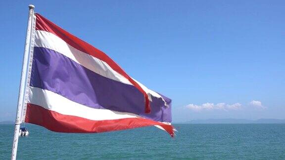 旗杆上的泰国国旗在风中以大海为背景的天空中泰国国旗