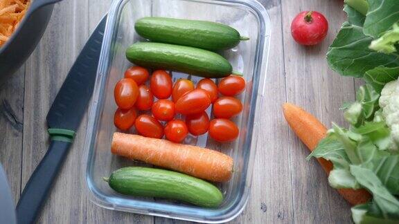 木桌上放着胡萝卜、黄瓜、西红柿和更多的蔬菜