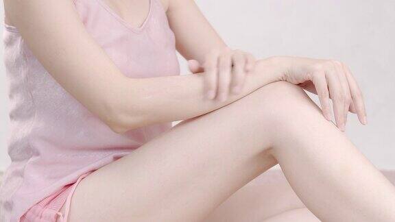 亚洲成年女性在手臂和手上涂抹保湿霜身体保健
