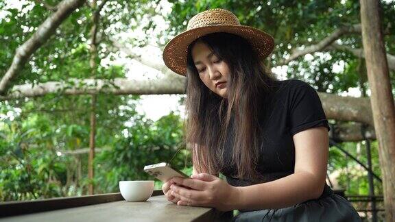 女子travelerÂ独自带着智能手机在户外与野生森林山脉在热带雨林的丛林