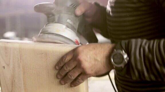 木匠用砂光机打磨木头的特写