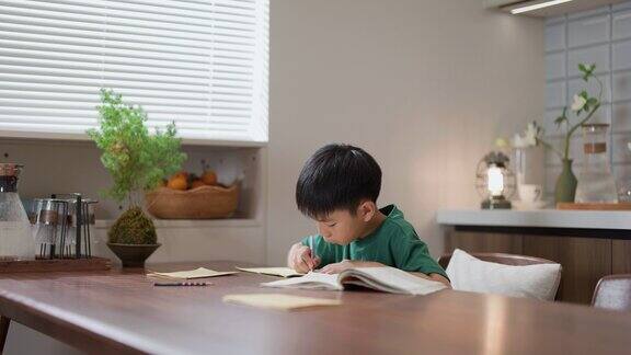 一个亚洲小男孩在家里做作业