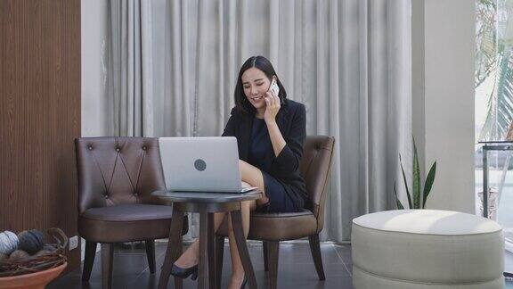 亚洲女商人在明亮的休息区使用笔记本电脑