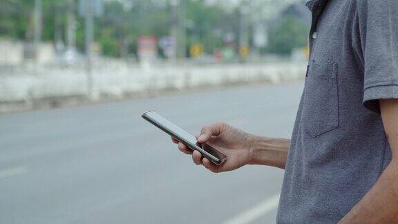 亚洲男子在路边用智能手机