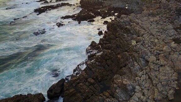 航拍下海浪撞击岩石的画面