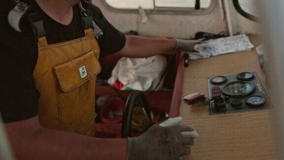 30岁出头的白人渔民驾驶小型拖网渔船