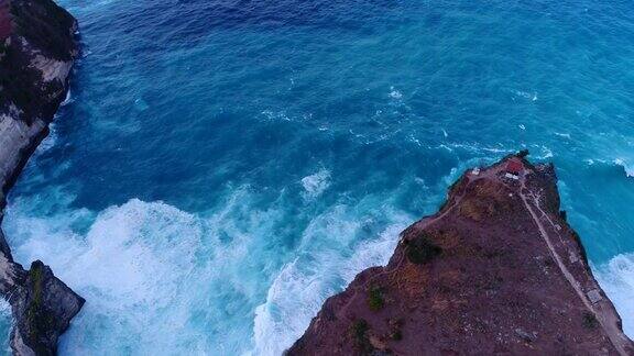 航拍海湾碧蓝的海水岩石峭壁和海浪碰撞