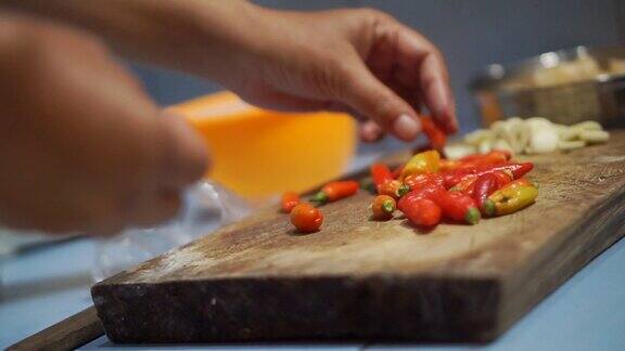 女人用菜刀切红辣椒的手