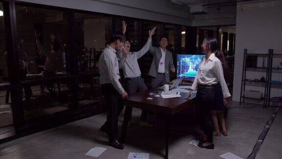4K分辨率快乐亚洲商务团队快乐跳舞结束工作后商务人群成功在办公室