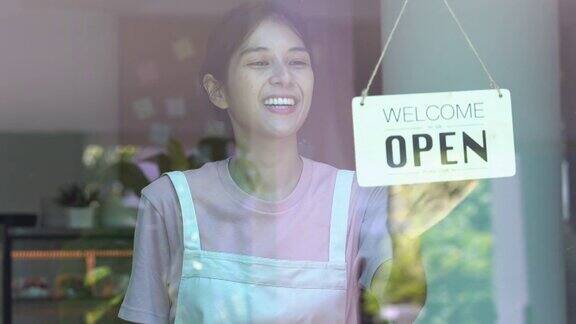 4K亚洲女服务员在咖啡店的门上挂着开门的标志