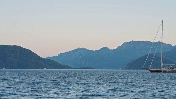 帆船停泊在海湾与清澈和蓝绿色的水日落游艇在马尔马里斯港口土耳其风景优美有海有山