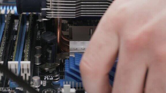 建一台电脑近景4K一名男性服务人员在PC主板的CPU上安装一个冷却散热器
