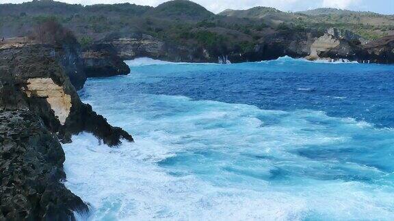 蓝绿色的海洋海水白色的波浪溅深蓝色的大海鸟瞰怪物波浪飞溅在岩石上热带海滩在夏季海边户外大洋岛风景优美引人注目