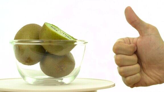 新鲜、成熟、绿色的猕猴桃在旋转碗中用手竖起大拇指
