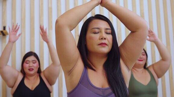 一群亚洲妇女在健身房一起练习瑜伽