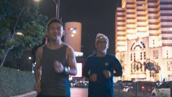一名亚裔中国男子鼓励他的父亲晚上下班后一起在城市里慢跑