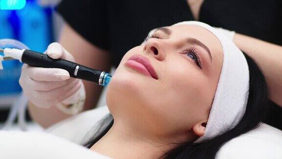 美容诊所专业女美容师在工作时正在做面部补水手术漂亮的女人躺在医疗床上做美容手术