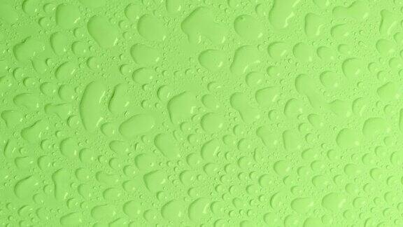 旋转橄榄或绿色粉彩背景与水滴或透明化妆品凝胶液透明质酸俯视图