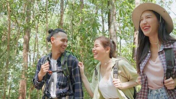 一群亚洲背包客在森林里玩得很开心迷人的男人和女人的朋友旅行散步和探索自然木材与快乐在暑假假期旅行