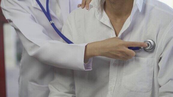 一位女医生拿着听诊器检查病人在医院里一位心脏病专家在体检时检查一名男性的心跳心脏保健