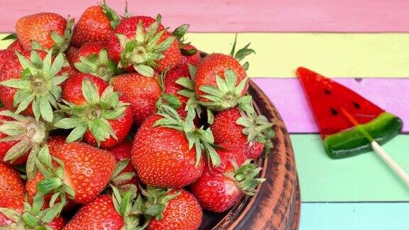 成熟的红草莓在陶瓷盘子上慢慢旋转