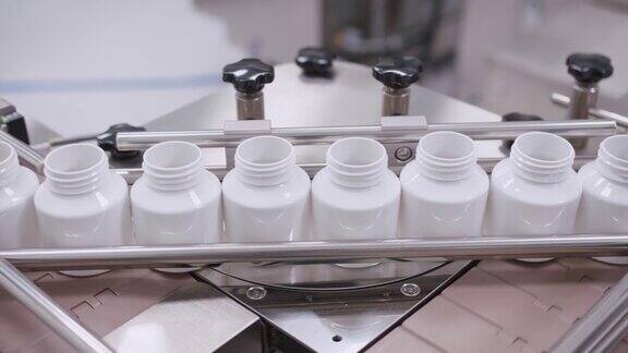 药品生产线上塑料容器的特写在制药厂空药瓶正沿着传送带移动