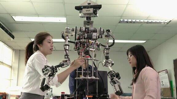 亚洲工程师在现代实验室协作开发机器人开发人员试验控制微芯片和制造电子产品技术、机器人工程和工业机器人