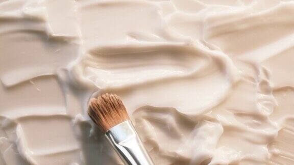 在白色背景上涂抹奶油使用笔刷润肤霜质地特写化妆品和美容产品概念化妆品