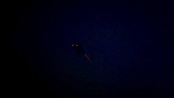 照亮了夜晚在城市上空飞行的直升机