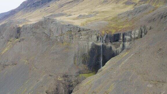 空中接近的瀑布在岩石和火山山景观冰岛