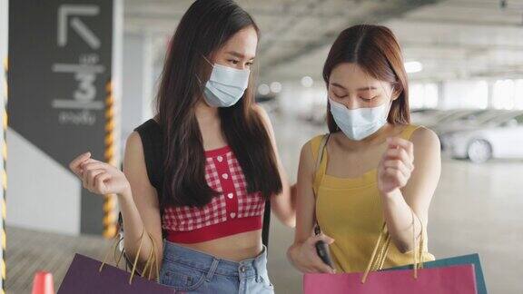 购物新常态亚洲女性带着面膜在服装店购物
